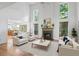 Open living room with high ceilings, a fireplace, lots of windows, and hardwood floors for natural light at 3570 Bardfield Ct, Cumming, GA 30041