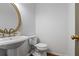 Stylish powder room featuring a pedestal sink, gold mirror, and neutral color scheme at 3570 Bardfield Ct, Cumming, GA 30041