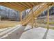 Shot from under the back deck showcasing the backyard, wood stairs, and a concrete patio for outdoor enjoyment at 4410 Ross Estates Ct, Snellville, GA 30039