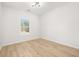 Large, empty room with light wood flooring and natural light from the window at 4410 Ross Estates Ct, Snellville, GA 30039