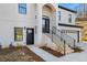 Close up of home's front door, steps, and walkway, showing black railings and a glass storm door at 4410 Ross Estates Ct, Snellville, GA 30039