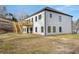 Rear of the home with a new wood deck with stairs, well maintained lawn, and black window trim at 4410 Ross Estates Ct, Snellville, GA 30039