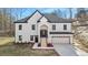 Beautiful two-story home with white brick, black trim, covered entry, and attached two-car garage at 4410 Ross Estates Ct, Snellville, GA 30039