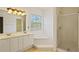 Bright bathroom with double sinks, a tub, and a glass-enclosed shower at 5923 Rosie Se Ln, Mableton, GA 30126