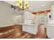 Open-concept living space with hardwood floors, white kitchen island, and elegant lighting fixtures at 5923 Rosie Se Ln, Mableton, GA 30126