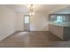 Open-concept living space with hardwood floors, modern light fixture, and kitchen view at 7156 Whitfield Drive Dr, Riverdale, GA 30296