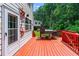 Orange painted wooden deck with grill and seating area for outdoor living at 1115 Ballington Dr, Cumming, GA 30041