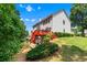 Spacious backyard with a red deck, stairs, and wooded area provides a private outdoor retreat at 1115 Ballington Dr, Cumming, GA 30041