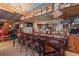 Unique in-home bar with wood paneling, bar stools, and an extensive liquor collection at 1115 Ballington Dr, Cumming, GA 30041