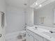 Bright bathroom featuring double sinks, a large mirror, and tiled shower and tub at 1115 Ballington Dr, Cumming, GA 30041