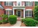Charming brick home entrance featuring a black front door and manicured landscaping at 1115 Ballington Dr, Cumming, GA 30041