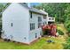 Two-story home with a red deck, well-maintained lawn, and lush landscaping create a serene outdoor space at 1115 Ballington Dr, Cumming, GA 30041