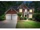 Traditional brick home with a manicured lawn and a two-car garage at 1115 Ballington Dr, Cumming, GA 30041
