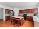 Modern kitchen with stainless steel appliances, cherry cabinets, island, and hardwood floors at 1115 Ballington Dr, Cumming, GA 30041