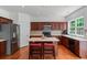 Well-appointed kitchen featuring stainless appliances, cherry cabinets, island, and hardwood floors at 1115 Ballington Dr, Cumming, GA 30041