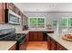 Well-lit kitchen boasts stainless steel appliances and wood cabinets at 1115 Ballington Dr, Cumming, GA 30041