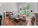 Sunlit living room with soaring ceilings, hardwood floors, access to deck, and views into the kitchen at 1115 Ballington Dr, Cumming, GA 30041