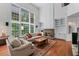 Inviting living room with stone fireplace, built-in bookshelves, and large windows offering natural light at 1115 Ballington Dr, Cumming, GA 30041