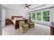Main bedroom features tray ceilings, a ceiling fan, and multiple windows at 1115 Ballington Dr, Cumming, GA 30041