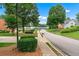 Street view showing well-maintained landscaping, a sidewalk, and a glimpse of a lake at 1115 Ballington Dr, Cumming, GA 30041
