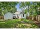 Backyard with a green lawn, perimeter wooden fence, mature trees, and a view of the rear house elevation at 2485 Hillside Ave, Decatur, GA 30032