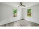 Cozy bedroom with hardwood floors and view to backyard and fence through two windows at 2485 Hillside Ave, Decatur, GA 30032