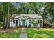 Charming home featuring a manicured lawn, light-colored facade, and inviting front porch with a bright teal front door at 2485 Hillside Ave, Decatur, GA 30032
