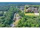 An aerial view showcases a distinguished two-story home within a lush, green neighborhood, accented with mature trees at 2525 Well Springs Dr, Buford, GA 30519