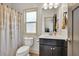 Bathroom featuring a sink vanity, toilet, and a window with decorative shower curtain at 2525 Well Springs Dr, Buford, GA 30519