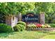 The Meranova at Mill Creek community sign amidst landscaped greenery and colorful flowers at 2525 Well Springs Dr, Buford, GA 30519