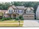 Inviting two-story home boasting a brick facade, two-car garage, landscaped front yard, and covered entrance at 2525 Well Springs Dr, Buford, GA 30519