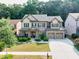 Two-story home featuring a brick facade, manicured lawn, and a two-car garage at 2525 Well Springs Dr, Buford, GA 30519