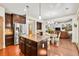 Open kitchen with granite island, stainless appliances, dark cabinets, and seamless access to living space at 2525 Well Springs Dr, Buford, GA 30519