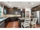 Gourmet kitchen with stainless appliances, granite counters, dark wood cabinets, kitchen island, and breakfast bar seating at 2525 Well Springs Dr, Buford, GA 30519