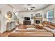 Cozy living room featuring hardwood floors, stone fireplace, ceiling fan, and staircase at 2525 Well Springs Dr, Buford, GA 30519