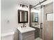 Modern bathroom featuring gray vanity, framed mirror, and a glass-enclosed shower with gray tiling at 888 Tucker Rd, Stone Mountain, GA 30087