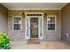Close up of the front porch with stone facade and decorative windows on either side of the doorway at 99 Rainwater Ln, Dallas, GA 30157