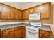 Close-up of kitchen featuring white gas range, oak cabinets, and gray countertops at 99 Rainwater Ln, Dallas, GA 30157