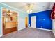 Bright and sunny living room with blue accent wall, carpet floors, and connecting kitchen at 99 Rainwater Ln, Dallas, GA 30157
