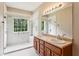 Bright primary bathroom featuring a double sink vanity, large mirror, and accessible glass enclosed shower at 99 Rainwater Ln, Dallas, GA 30157