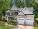 An aerial view of a two-story home with stone accents, lush landscaping, and a two-car garage at 1205 Compass Pointe Xing, Alpharetta, GA 30005