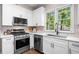 Well-appointed kitchen with stainless steel appliances, white cabinets, and a stylish backsplash at 1205 Compass Pointe Xing, Alpharetta, GA 30005