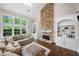 Bright living room with stone fireplace, built-in bookshelves, and large windows with wooded view at 1205 Compass Pointe Xing, Alpharetta, GA 30005