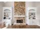 Cozy living room featuring a stone fireplace, built-in shelving, and hardwood floors at 1205 Compass Pointe Xing, Alpharetta, GA 30005