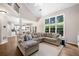 Living room with large windows offering natural light and view of the outdoors, open to the kitchen and dining area at 1205 Compass Pointe Xing, Alpharetta, GA 30005