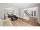 Bright living room with hardwood floors and views to the foyer with staircase and dining room with natural light at 1205 Compass Pointe Xing, Alpharetta, GA 30005