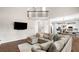 Open-concept living room adjacent to kitchen with modern lighting, and large sectional sofa at 1205 Compass Pointe Xing, Alpharetta, GA 30005