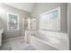 The bathroom features a soaking tub, tiled floors, a walk-in shower and multiple windows at 1205 Compass Pointe Xing, Alpharetta, GA 30005