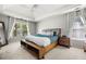 This cozy main bedroom features large windows, a tray ceiling with fan and carpet flooring at 1205 Compass Pointe Xing, Alpharetta, GA 30005