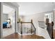 Staircase landing featuring wood floors, metal railing, and open doorways to bedrooms and other rooms at 1205 Compass Pointe Xing, Alpharetta, GA 30005